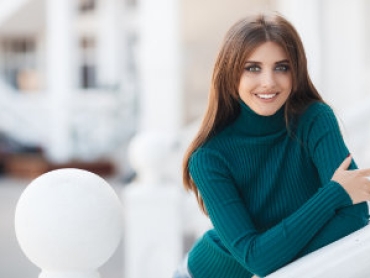 long haired brunette with a beautiful smile in a turquoise sweater